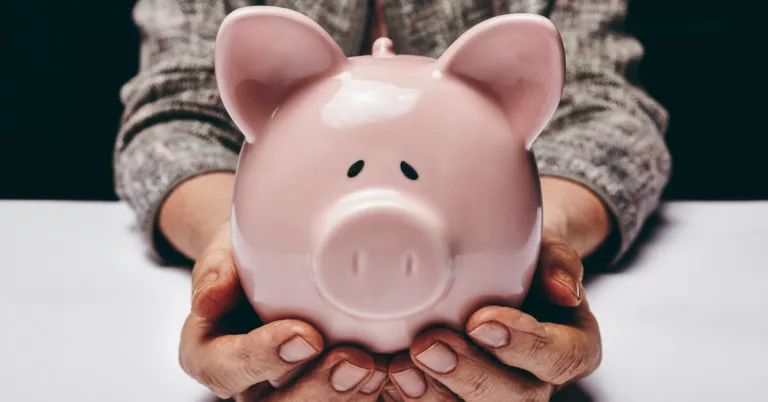 Elderly Woman Holding Pink Piggy Bank